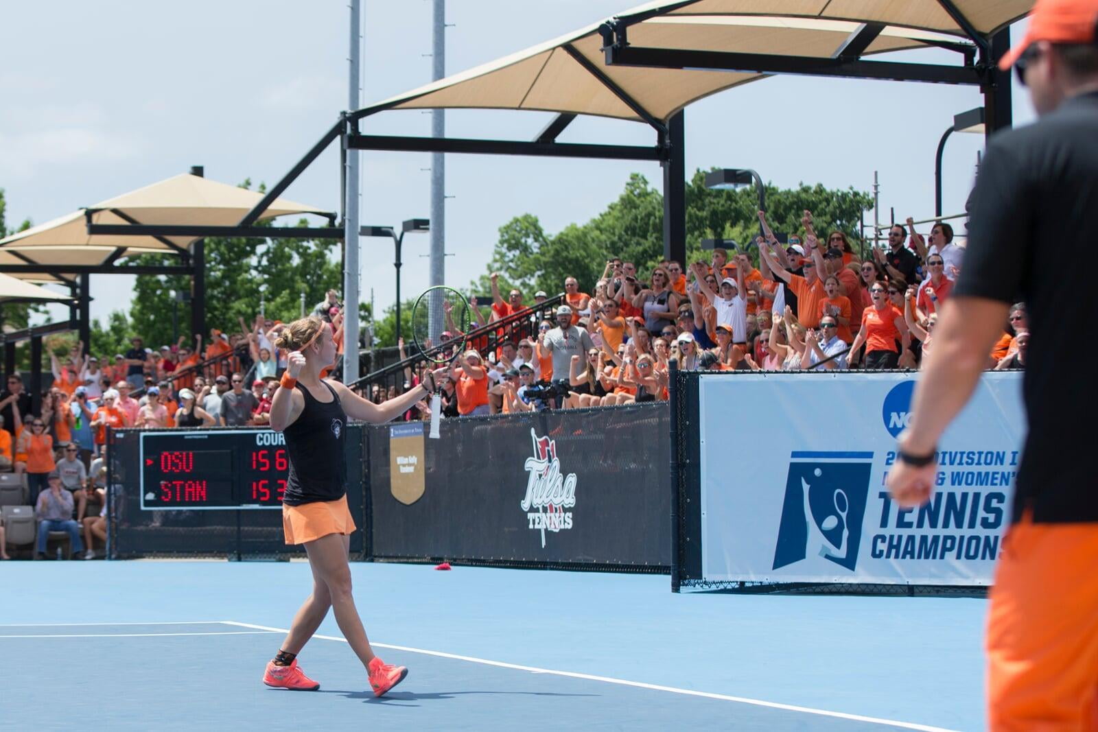 female college tennis player fisting pumping to the crowd on a tennis court