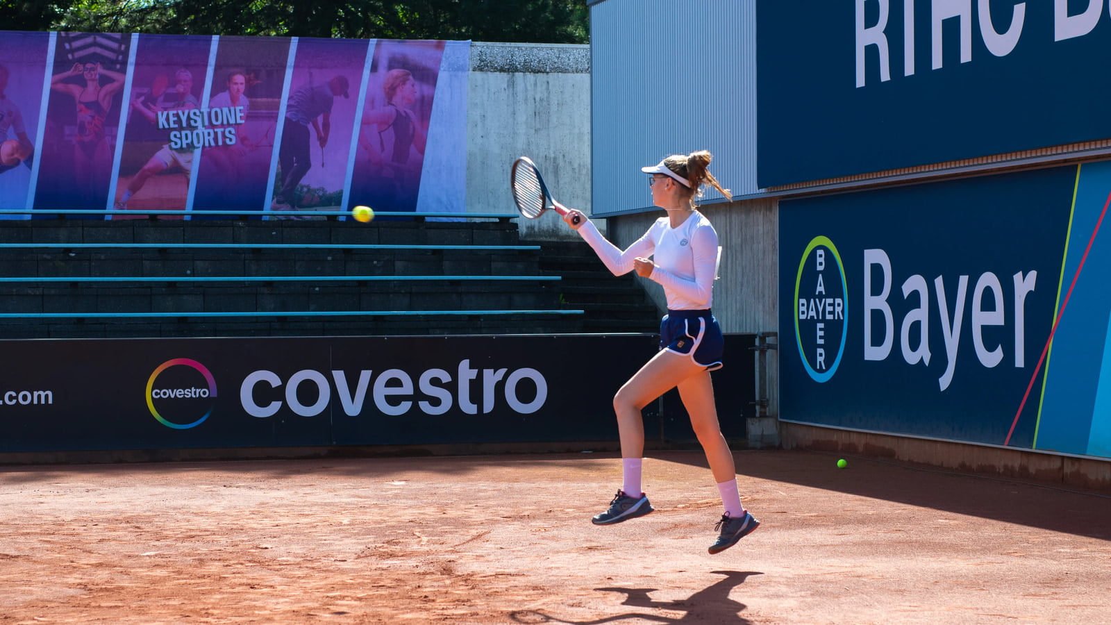 Lefty male tennis player with an all white outfit is serving