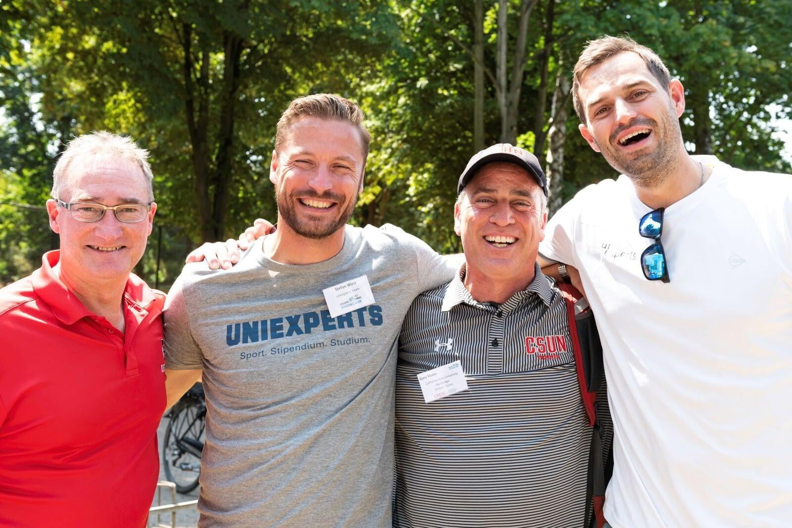 two male college coaches and two college recruiters standing next to each other