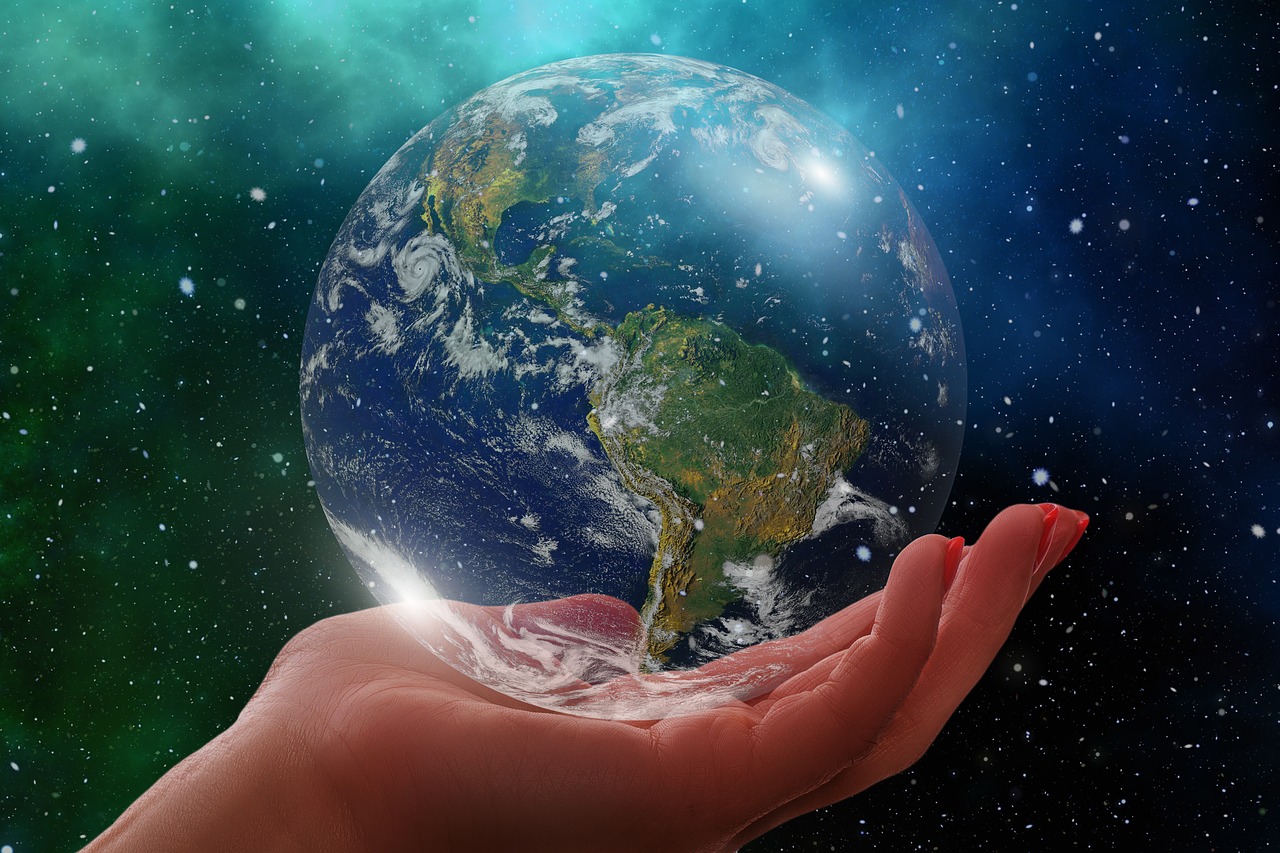 human hand holding a transparent planet earth