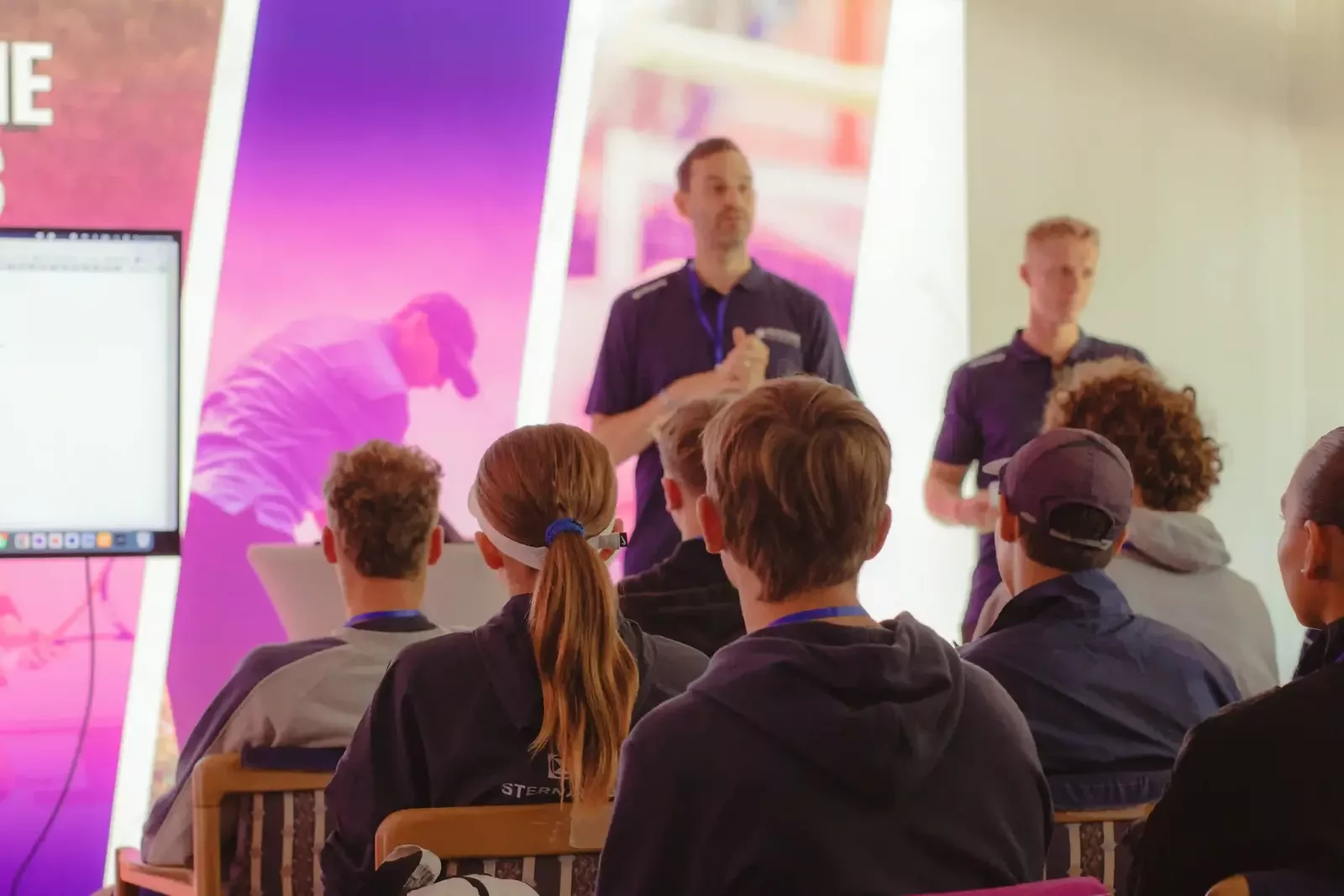 male college tennis experts talks in front of tennis players